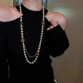 Dettaglio collana a due strati con perline e ciondolo a fiore dorato indossata su modella - Collana a Doppio Strato di Perle e Fiori Bianco