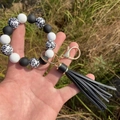 Detail of leopard print silicone beads on a keychain bracelet with black leather tassel - Black