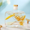 Square reed diffuser bottle with yellow dried flowers and gold cap for home fragrance - Fragrans