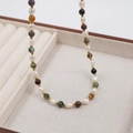 Colorful gemstone and freshwater pearl necklace with gold spacer beads on a beige display - Dopamine Multicolored Beads