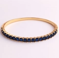Detail of 18K gold-plated cuff featuring a row of square blue zircon stones on metal - Blue Zircon
