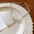 Elegant cream pearl necklace featuring a central bow charm and tassel detail - White with Bowknot