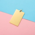 Close-up of golden rectangular stainless steel pet tag with polished mirror finish - Gold With Clasp
