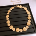 Dettaglio della cintura a catena dorata vintage con ciondoli circolari testurizzati - Oro
