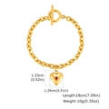 Dettaglio macro di un bracciale a catena con fibbia OT dorata, pendente a cuore e gemma - Oro Zircone Rosso