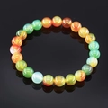 Macro shot of multi-colored translucent stone beads on an elastic bracelet with reflection - Malachite Stripe Agate