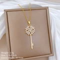 Dettaglio della collana con ciondolo a chiave in titanio dorato e cristalli su seta - Chiave a Fiore Traforata / Oro