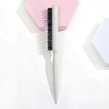 Detailed view of professional teasing brush with white handle and mixed bristle texture - Plastic / White