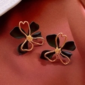Detailansicht eleganter schwarzer Blumenstecker mit goldenen Akzenten auf Stoffhintergrund - 18# Schwarz (925 Sterling Silber Ohrstecker)