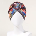 Detail van een bohemian tulband met rode bloemknoop en vintage etnische printmotief - Rood
