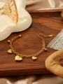 Dettaglio dei ciondoli a cuore dorato e campanellini sul bracciale a doppia catena - Bracciale Con Cuore E Campanello (ZHB1050金)