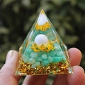 Green crystal resin pyramid with gold flakes and lotus detail held in hand - White Ball Green Aventurine / Small
