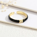 Detailed close-up of a 18K gold plated ring with black enamel and a micro-set zircon stone - Adjustable Open / Black