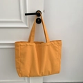 Detail of a bright yellow canvas tote bag hanging on a door handle showing large capacity - Solid Orange