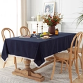 Solid deep blue cotton tablecloth with white pom-pom trim on a wooden dining table - 60X60CM (2 Pcs) / Washed Cotton Navy Blue + White Pom Pom