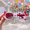 Cute white kids sunglasses with red polka dots and bow detail held in hand - White Polka Dot