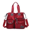 Detalle del bolso rojo de tela Oxford con múltiples bolsillos y asas de gran resistencia - Rojo