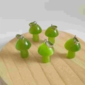 Miniature green natural stone mushroom pendants with silver loops on a wooden base - Synthetic Fruit Green Cat Eye