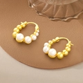 Elegant gold hoop earrings with white pearls on a textured dark background - Pearl Hoop Hooks / Gold