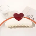 Detail shot of a cream-colored hair claw clip with red heart detail on a decorative tray - Heart Semicircle / Creamy White