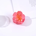 Detail of pink hibiscus hair claw clip with glossy finish and translucent gradient texture - Red