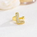 Close-up of a golden puffed letter L ring pavé set with sparkling cubic zirconia crystals - L