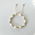 Adjustable beaded bracelet with gold round beads and white square crystals on a cream cord - White