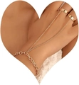 Elegante bracciale anello dorato con anello a cuore e catena sottile sulla mano della modella - Stile doppio dito dorato