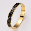 Golden stainless steel bangle featuring black enamel four-leaf clover motifs with clasp - Black Enamel