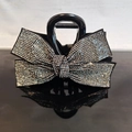 Dettaglio di una pinza per capelli nera con fiocco decorato da strass argentati - Strass Grigio Trasparente