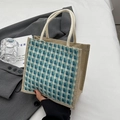 Blue and beige woven linen tote bag held by hand in a minimalist lifestyle setting - Zipper Style / Blue