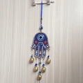 Hamsa Hand and Evil Eye wall hanging ornament with small gold bells on wooden door - Blue