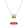 Elegante collar de acero de titanio dorado con un colgante cilíndrico de cristales - Dorado