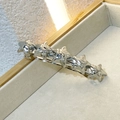 Close-up of five silver star charms on a polished metal hair clip in a wooden tray - Silver Stars