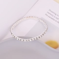 Detailed close-up of a silver rhinestone bracelet with sparkling zircon on ceramic - 1 Layer Style