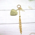Close-up of golden mesh drawstring pouch keychain with bow and heart pendants - Gold Round Heart (Heart Mirror Style)