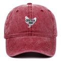 Macro shot of embroidered chicken dad patch on vintage washed burgundy cotton cap - Burgundy