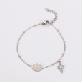 Detail van Sint-Benedictusmedaille en kruishanger aan roestvrijstalen armband op wit - Staalkleur