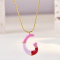 Detail of gold chain necklace with pink and white enamel letter G pendant craft - Letter G