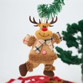 Detail of a plush reindeer Christmas ornament with red plaid scarf on a green tree branch - Elk