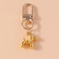 Macro detail of golden balloon dog keychain with spring lobster clasp and polished finish - Gold