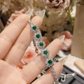 Close-up of floral emerald bracelet with silver setting and sparkling white diamonds - 5-Stone Green Gem Flower Style (0021)