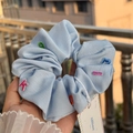 Light blue fabric scrunchie with colorful embroidered letters and brand hangtag - Haze Blue Letters and Numbers Fabric Scrunchie