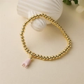 Gouden kralenarmband met roze emaille handgebaar hanger op een witte achtergrond - Roze