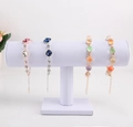 Elegant multi-color rhinestone and bead bracelets displayed on a white T-bar jewelry stand - White PU Leather