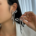 Macro shot of silver liquid metal bow earring with long fringe on model's ear - 3D Bow Knot (3492) / Silver (3492)