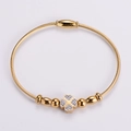 Bracciale rigido in filo d'acciaio dorato con quadrifoglio di cristalli e fibbia - Oro