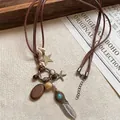Detalle de collar étnico con colgante de pluma y cuentas de madera sobre tela de lino - Estilo Pluma Pequeña Plateada (HN7384)