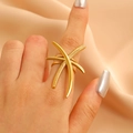 Macro shot of gold crisscross fishbone flower ring on champagne silk background - Crossed Star Strip (9857)