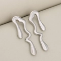 Minimalist silver liquid metal earrings with irregular fluid wave design on beige base - Silver